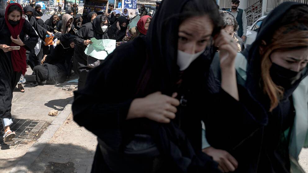 Kvinnliga demonstranter flyr från beväpnade talibaner under en demonstration för kvinnors rättigheter tidigare i år.