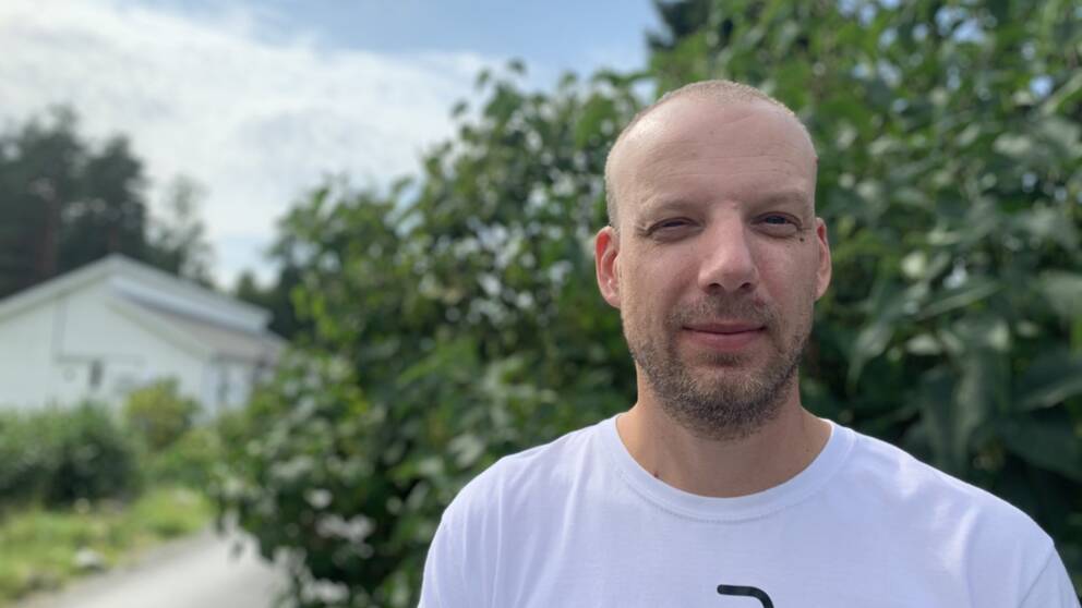 man med vit tröja och skäggstubb