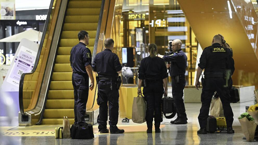 Poliser stående inne på Emporia efter dödsskjutningen.