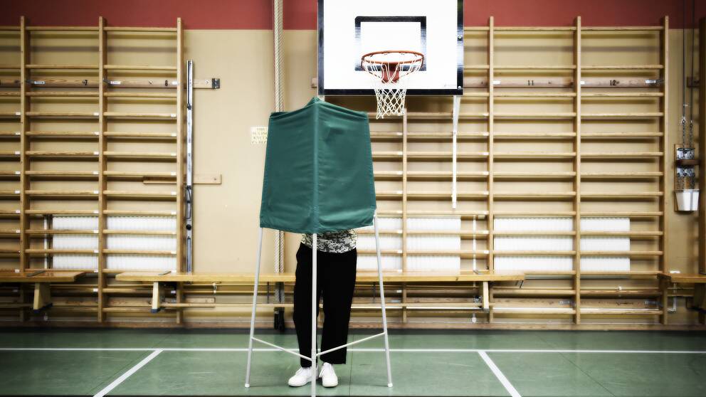 Person som röstar i en gymnastiksal.