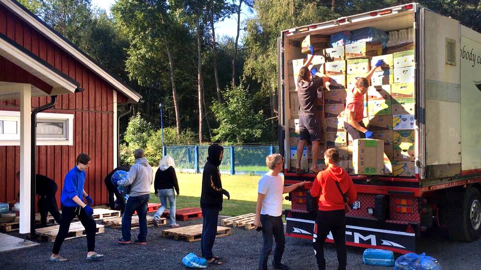 ungdomar i Lutsk lastar av kartonger från lastbilen från Skara