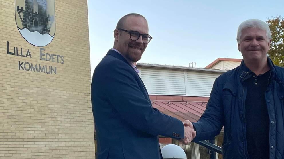 två män skakar hand framför Lilla Edets kommunhus