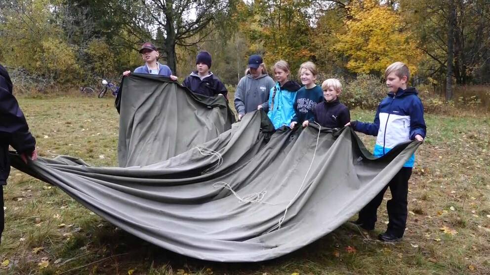 Elever från Mullhyttansskola, åk 5, hjälps åt att vika ihop ett militärtält.