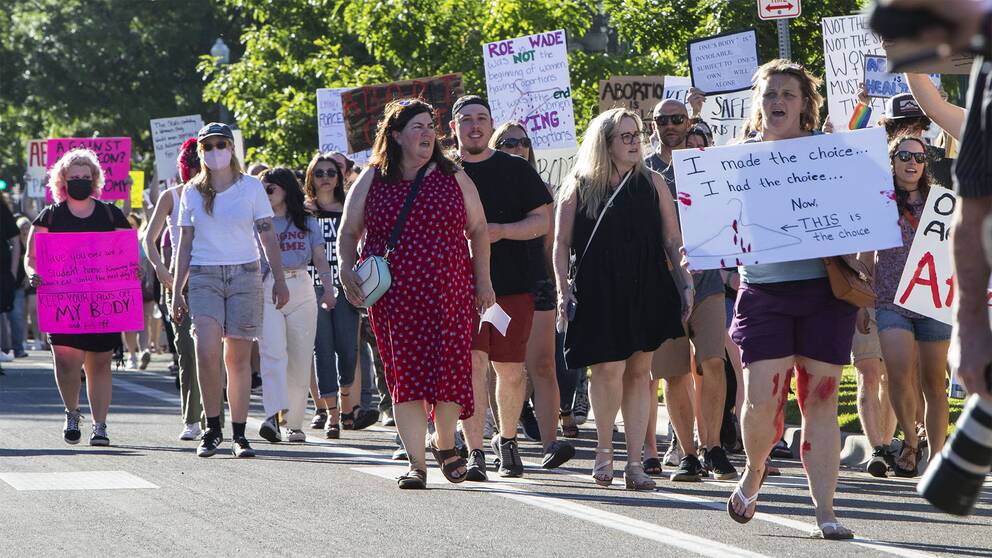 En stor grupp människor med plakat, mest kvinnor, som protesterar mot att rätten till abort har begränsats i USA.