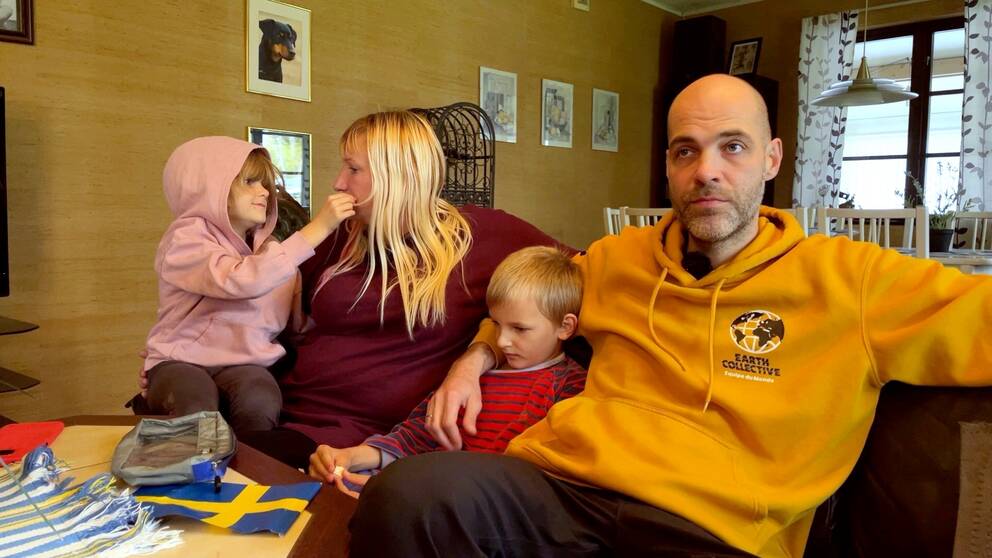 Två vuxna och två barn sitter i en soffa. Familjen flydde Ukraina och hamnade i Sverige. Men nu lämnar de landet för Norge.