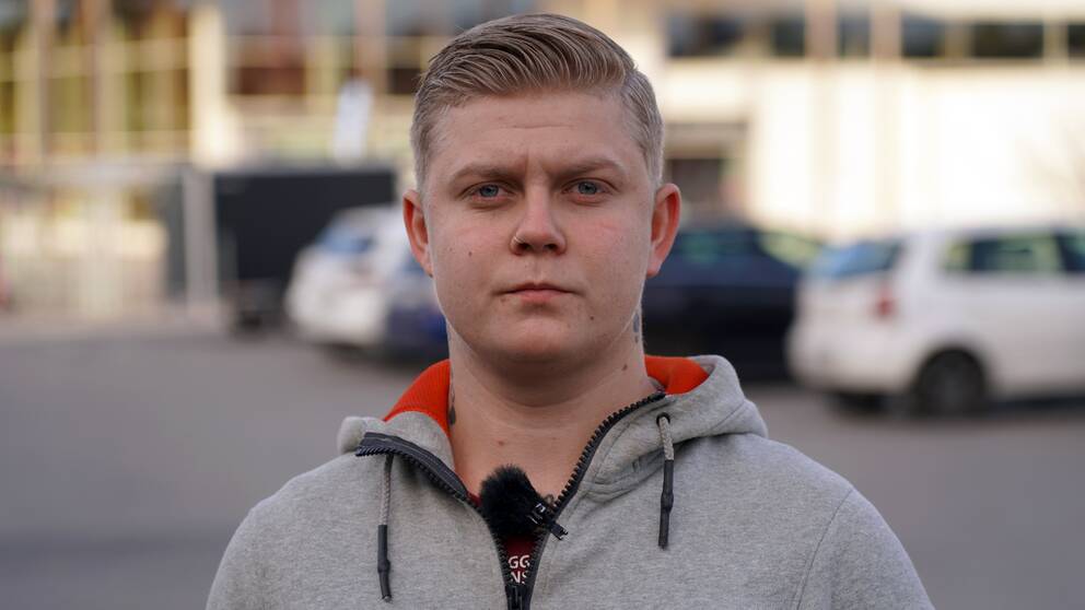 En man i 20-årsåldern står på en parkering.