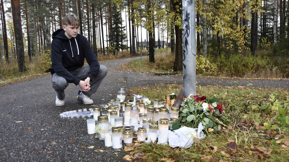 Kompisen Noel Tollbrant framför ljus och blommor som har lämnats på platsen där 16-åringen hittades död.