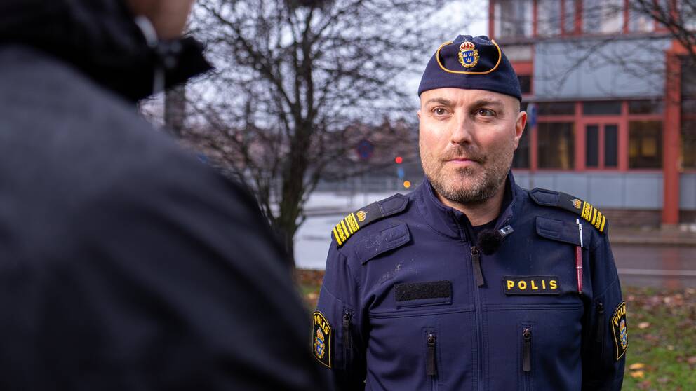 Temo Allenbäck, tillförordnad lokalområdeschef på Gävleborgspolisen, iklädd polisuniform, blir intervjuad utomhus om våldet i Gävleområdet.