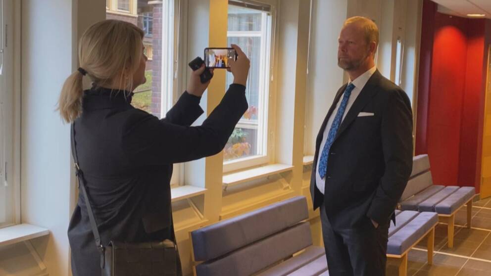 Till vänster i bild syns en kvinna som tar en bild på Daniel Nordfjell som står till höger.