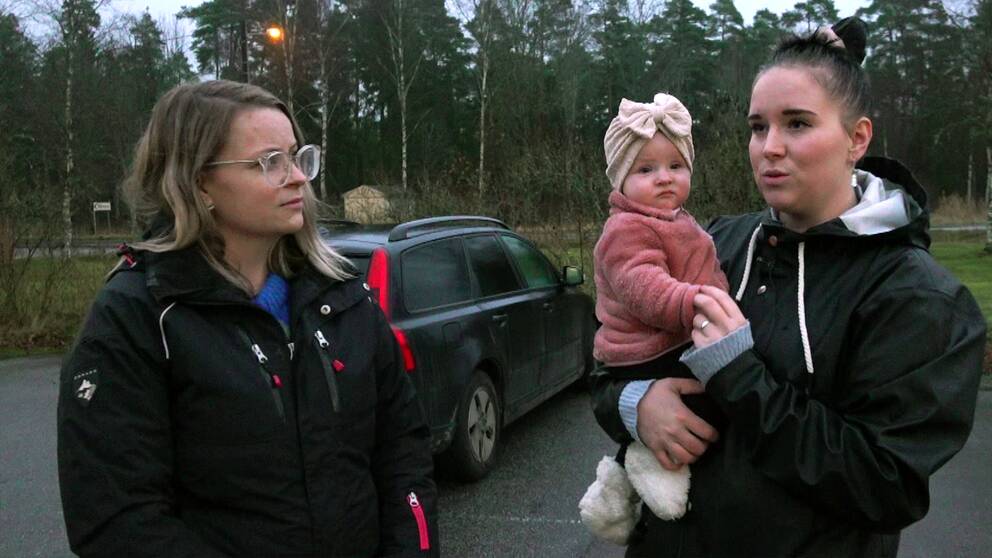 Föräldrarna Emma och Annie, Annie håller en liten bebis i famnen.