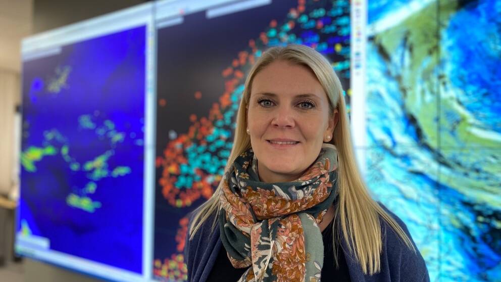 Meteorologen Linnea Rehn Wittskog står framför en helbildsskärm med väderbilder.