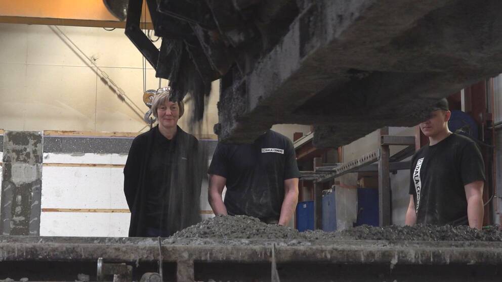 Apparat lägger cement, en kvinna kvinna i medelåldern står i bakgrunden