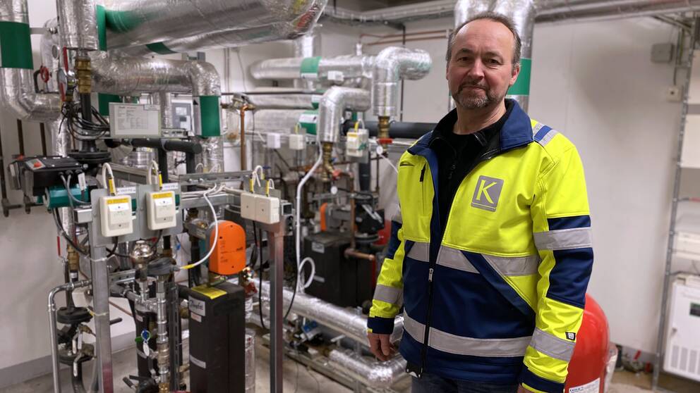 Kenneth Ahlström från Kopparstaden står i ett rum med fjärrvärmeledningar