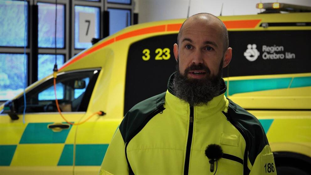 Bild på en uniformerad ambulansförare framför en ambulans. Ambulansföraren heter Erik Albinsson Kittang och han pratar i klippet om hur självlarmande bilar med Ecall ofta larmar falskt till SOS Alarm.