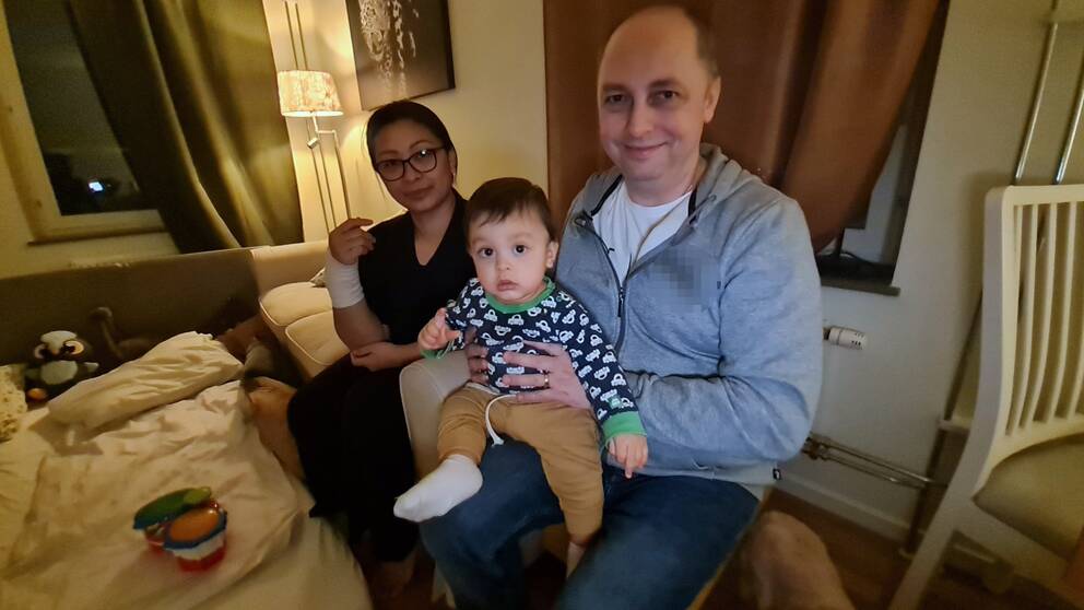 Familjen Majhem i en liten lägenhet i Malmö. Lille sonen Kevin i pappa Cristians famn och mamma Yanni till vänster om dem.