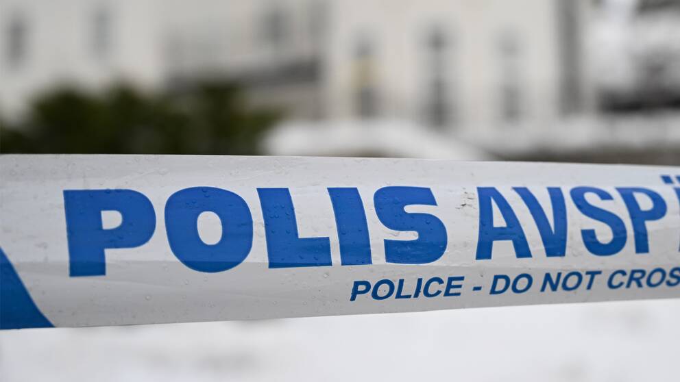 Polisavspärrning framför ett vitt hus
