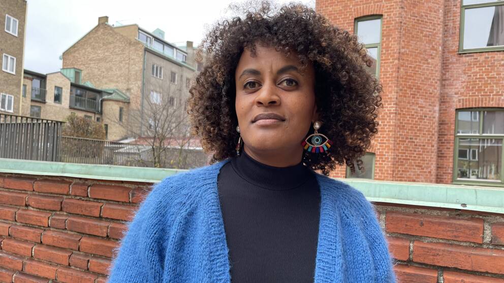 Lise Aragaw Johansson, tidigare socialsekreterare, står framför ett hus.