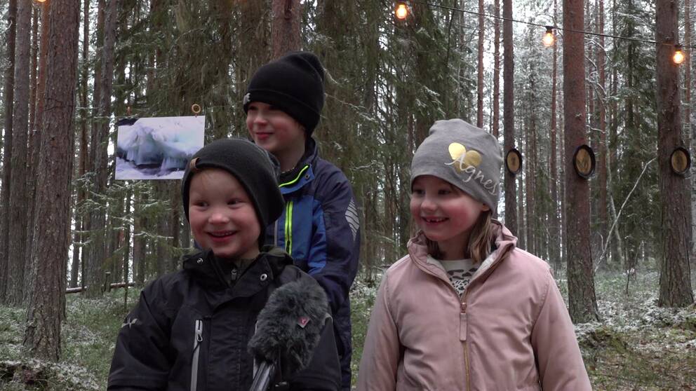 Tre glada barn på julmarknad.
