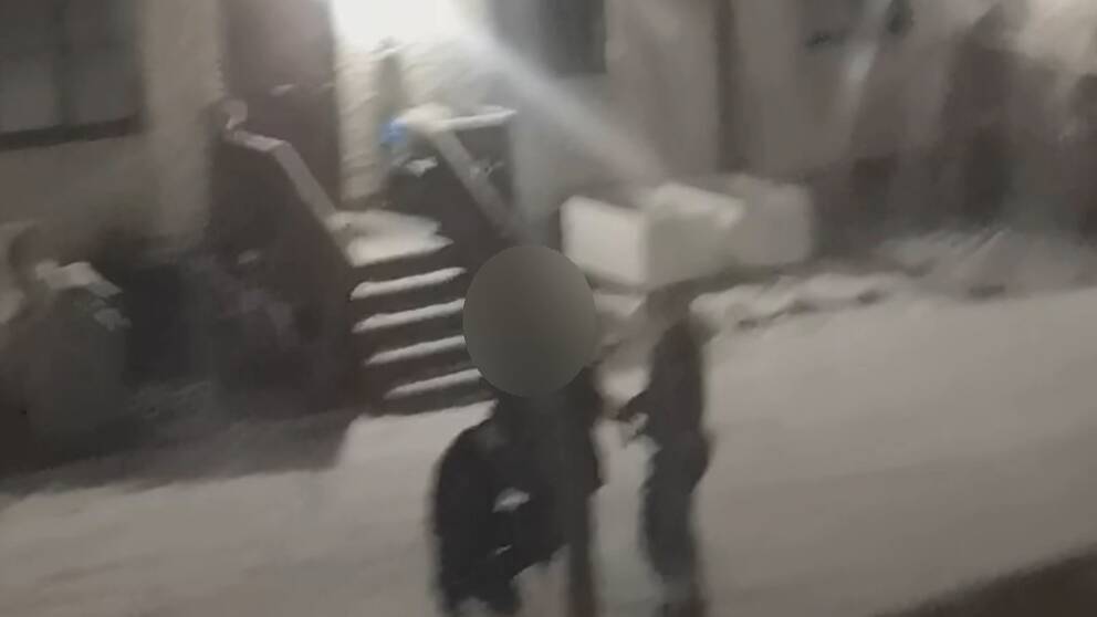 Se film från polisens ingripande. På bilden syns tre personer väldigt oskarpt. Snö på marken.