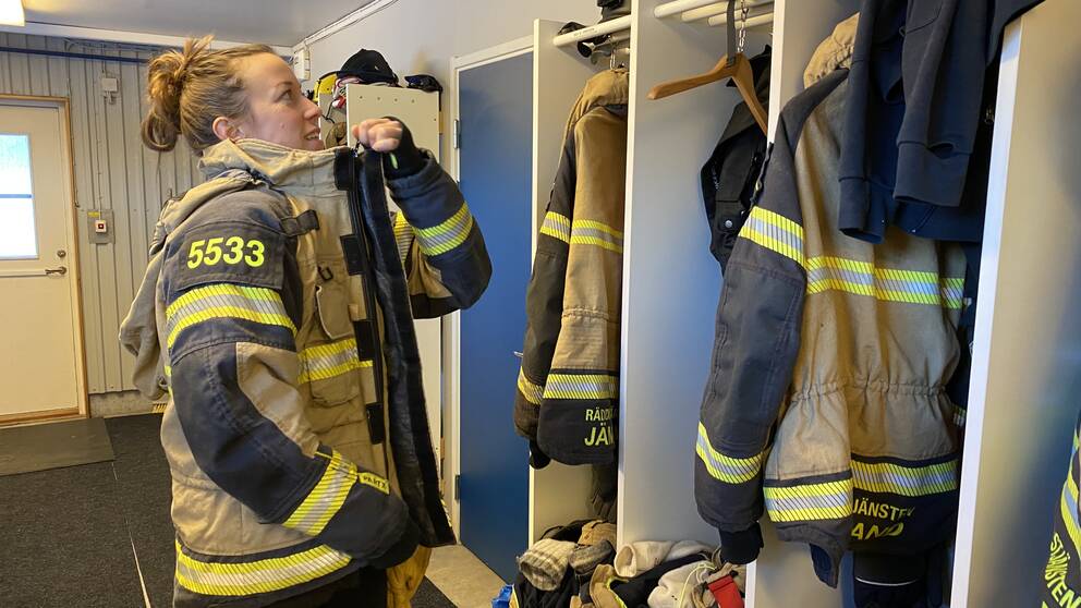 Mirjam Olsson, ny som räddningstjänstpersonal i beredskap, står i Vemdalens station och tar på sig och visar sina kläder som hon har på sig när hon ska göra en utryckning. Till jul har hon sin första jourvecka och hon ser fram emot den.