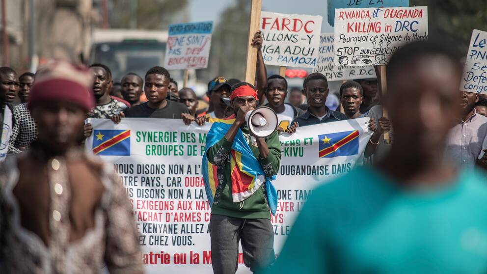 Invånare i Kongo-Kinshasa som protesterar med plakat