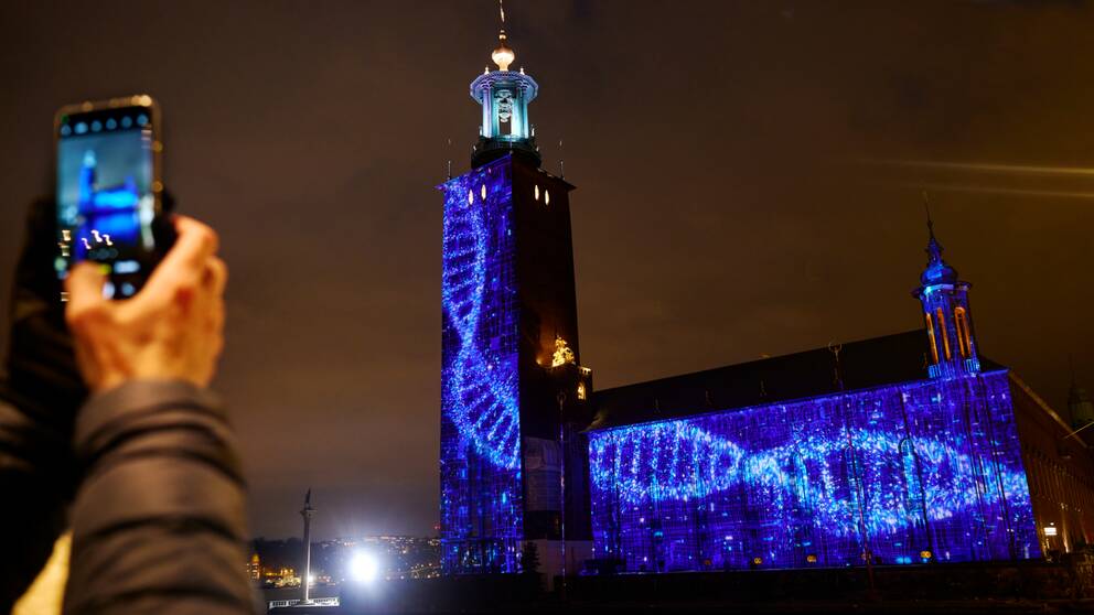 Stadshuset lyses upp av en ljusinstallation i blått under Nobel week light. 