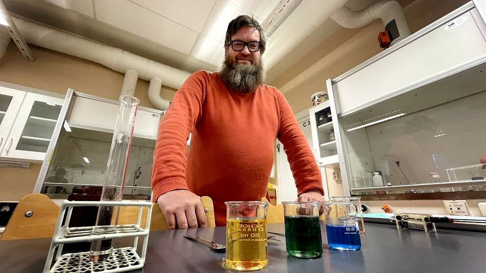 Kemimajjen Ronny redo att förklara vätgasens hemlighet på plats i kemisalen på Bobergsgymnasiet. De gröna, blåa och gula vätskorna framför honom kommer spela en viktig roll i detta. Ronny hade också en hälsning till tittarna – don´t try this at home!