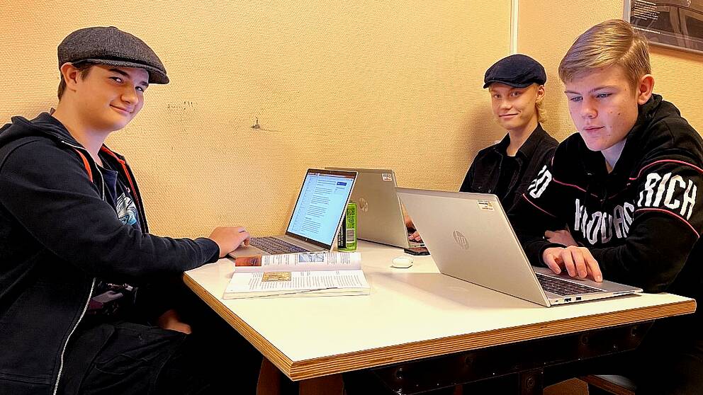 Elvis, Joshua och Liam, alla 16-åringar från Ånge, sitter inne i en skola och studerar med sina laptops.