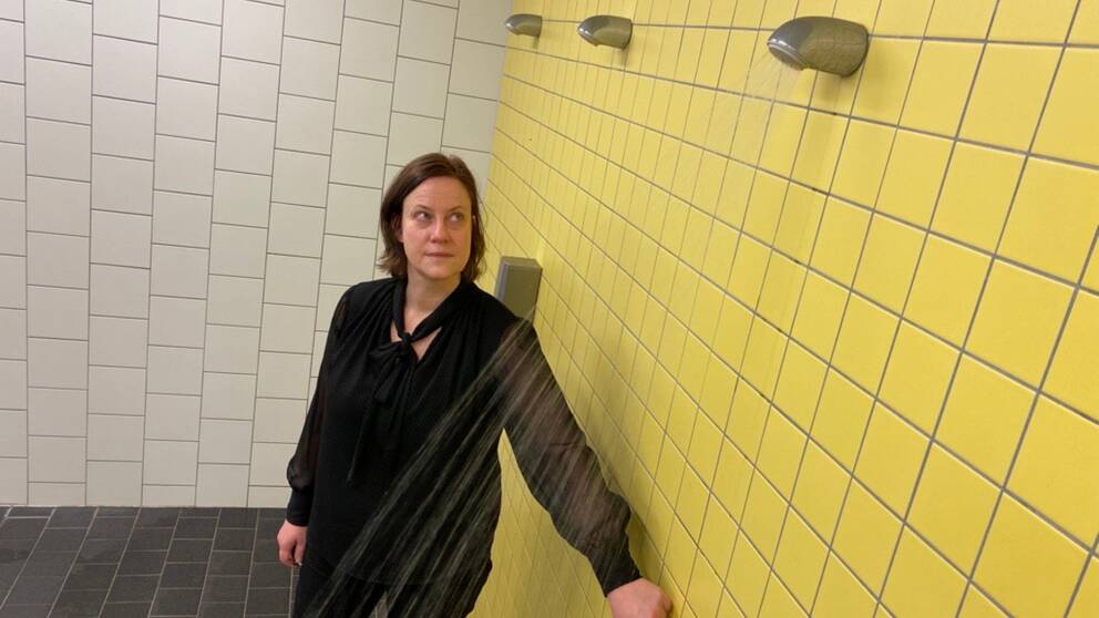 Miljöinspektör Eva Jansson vid Sundbybergs kommun startar en av duscharna i simhallens omklädningsrum.