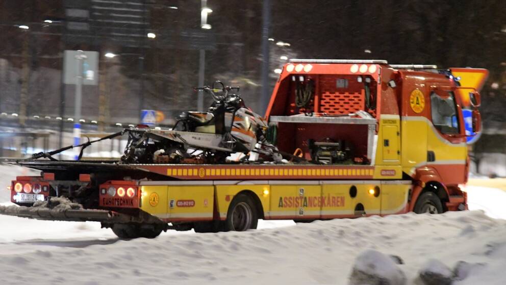På bilden syns assistanskåren som har en skoter på flaket. Miljön runtomkring bilen från assistanskåren är snö och mörkt.