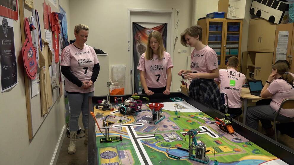 I bild syns sju elever på Västra skolan i Falun tillsammans med deras lärare. De har alla på sig rosa tröjor och står uppradade inför deras teknikbygge.