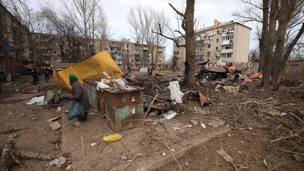En kvinna går runt i ett bostadsområde i staden Kostiantynivka, som drabbats av en rysk attack. 