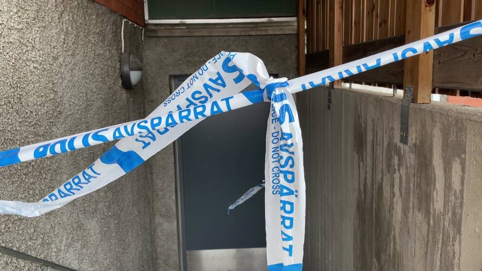 Bild på polisens avspärrningsband framför en ingång till ett bostadshus, i samband med polisens stora insats i Sundsvall.