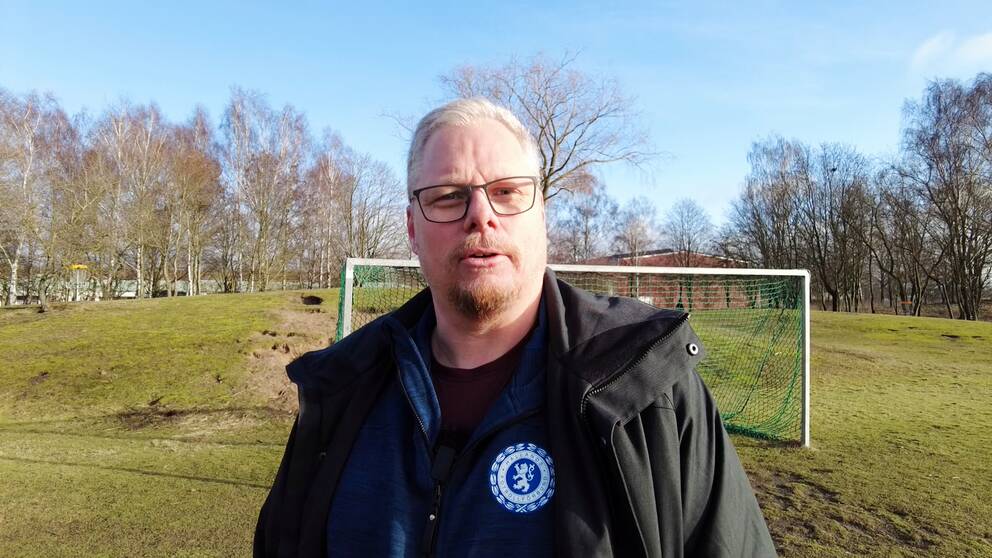Domarkonsulenten Jörgen Ahlgren från Hallands fotbollförbund står framför ett fotbollsmål.
