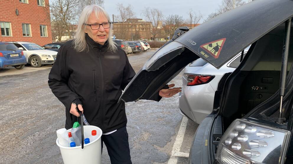 Gittan Gren lastar in städhinken i i bilen