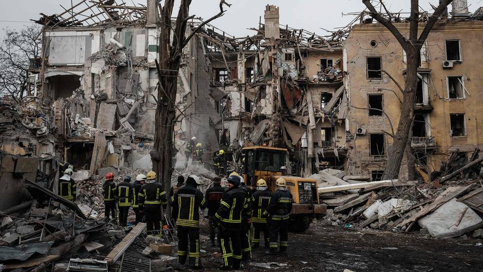 Räddningsarbetare i Donetsk vid ruinerna av ett flervåningshus.