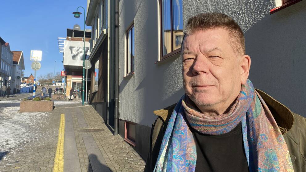 I bilden syns en man som står på en gata framför ett hus. Mannen heter Peter Bowin.