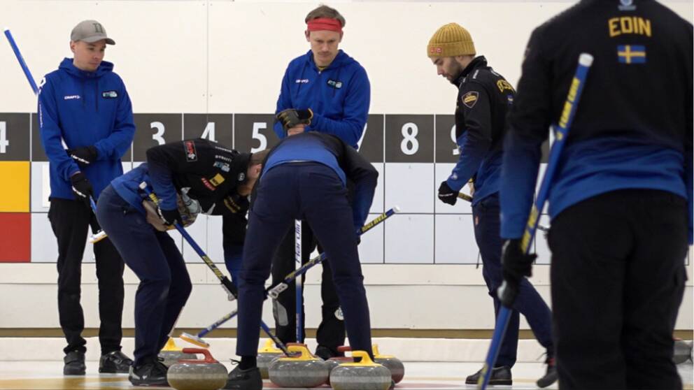 Flera curlingspeare står på en is (lag Edin)