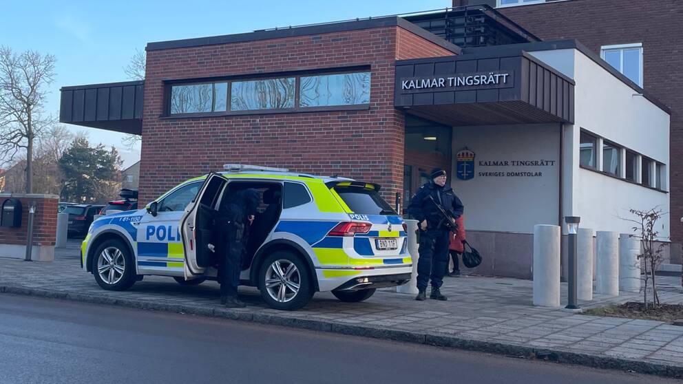Två beväpnade poliser vid en polisbil utanför Kalmar tingsrätt inför rättegången kring Ängö-mordet.