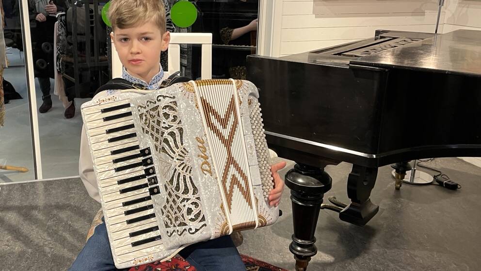 Mikola Mykytiuk från Ukraina spelar musik i butiken. På bilden sitter han med ett dragspel i famnen.