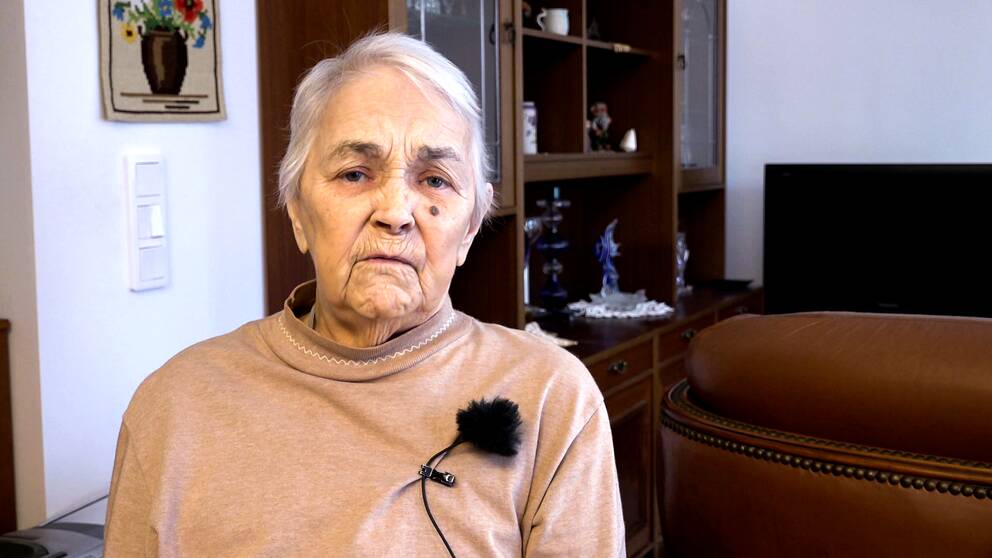Porträttbild på en 91-årig kvinna. Hon har kort vitt hår och beige tröja med halvpolo.
