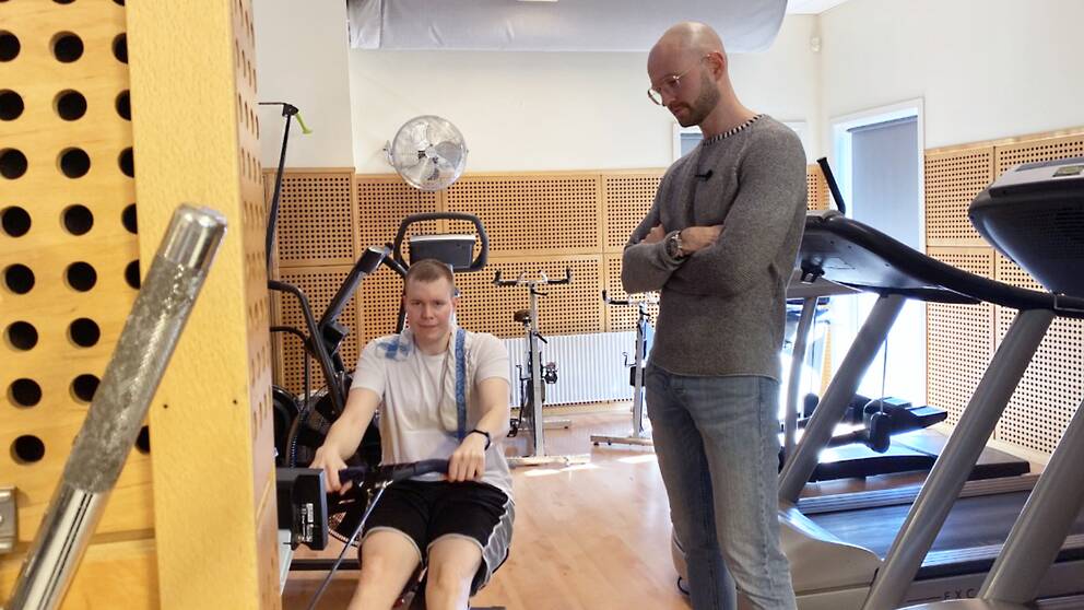 Dennis Carlsson tränar med hjälp av sin assistent på ett gym i Örkelljunga.