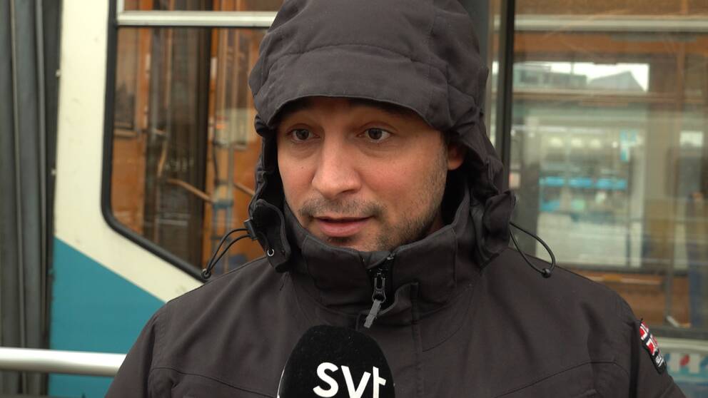 Adil El Harti blir intervjuad av SVT om biljettkontrollanter på Västtrafiks fordon, bakom honom skymtar en spårvagn.