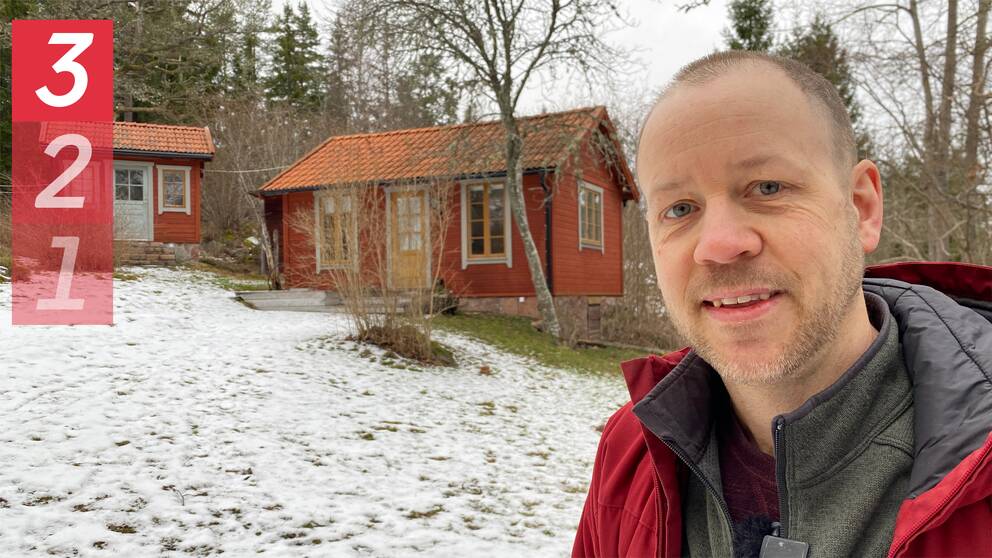 Man till höger i bild framför två röda stugor