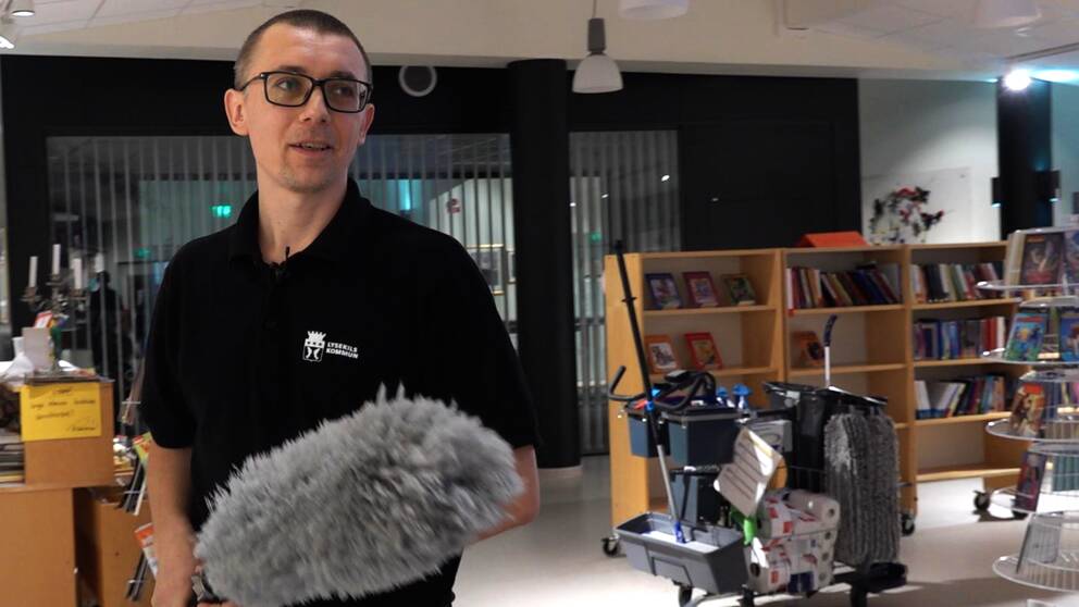 Volodymyr Ulianyk står bredvid en städvagn. Han har svart tröja och glasögon.