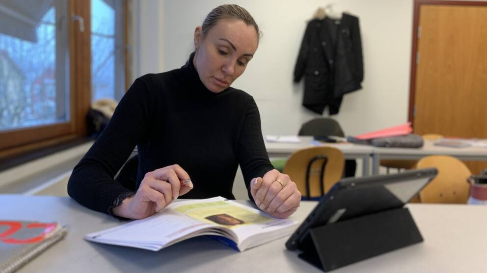 Viktoria Bryseh från Ukraina studer sfi i Vaggeryd. Hon sitter vid en bänk och läser en lärobok.