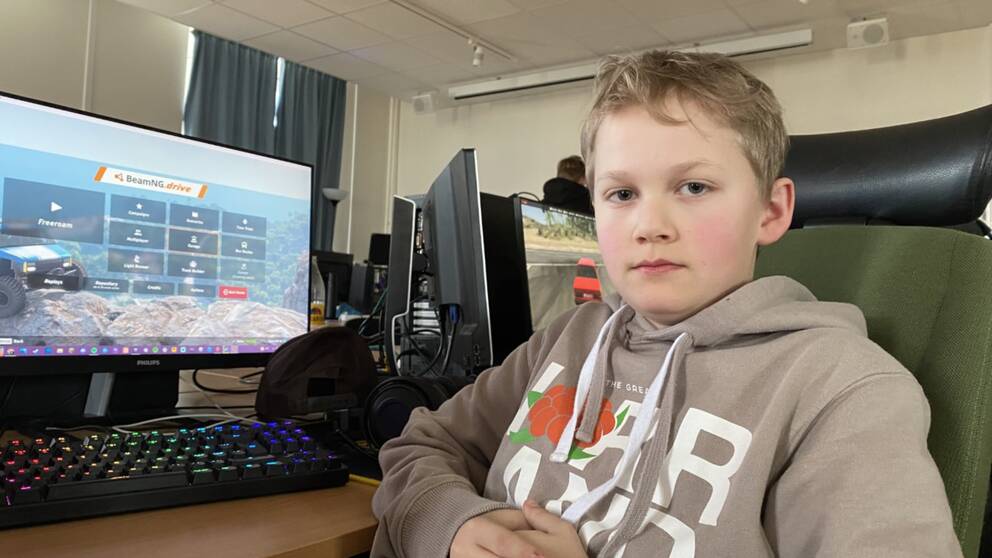 En kille sitter framför en dator.