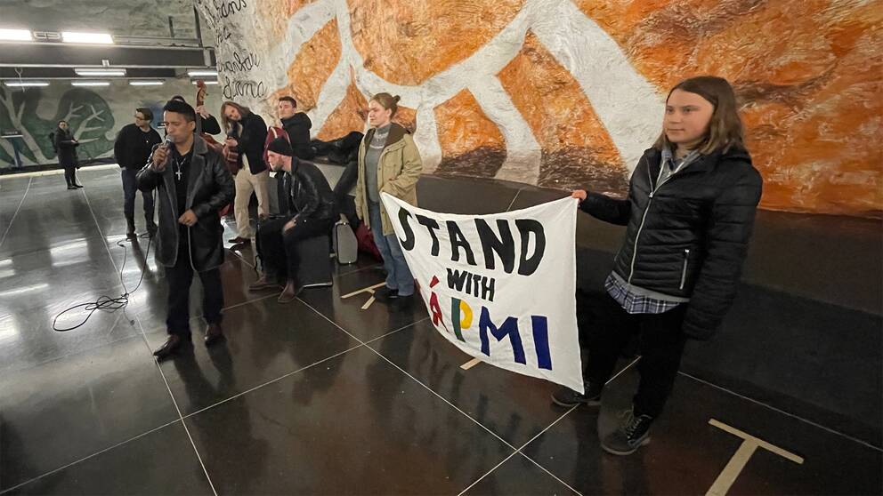 Här dyker Jon-Henrik Fjällgren och Greta Thunberg upp på Tensta tunnelbanestation.