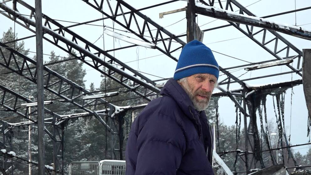 Thomas Wassberg står vid en brandhärjad metallstruktur som var en del av Åsarna ski center.
