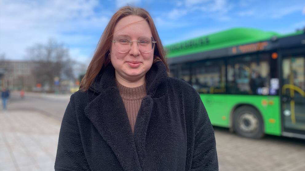 Halvbild på Mikaela Bech, glasögon, rödaktigt hår, ler med stängd mun.